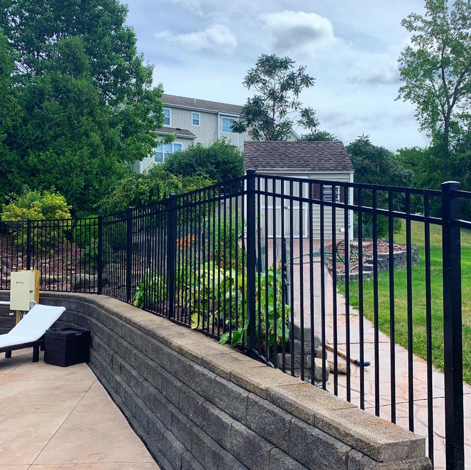 Black aluminum fence on retaining wall