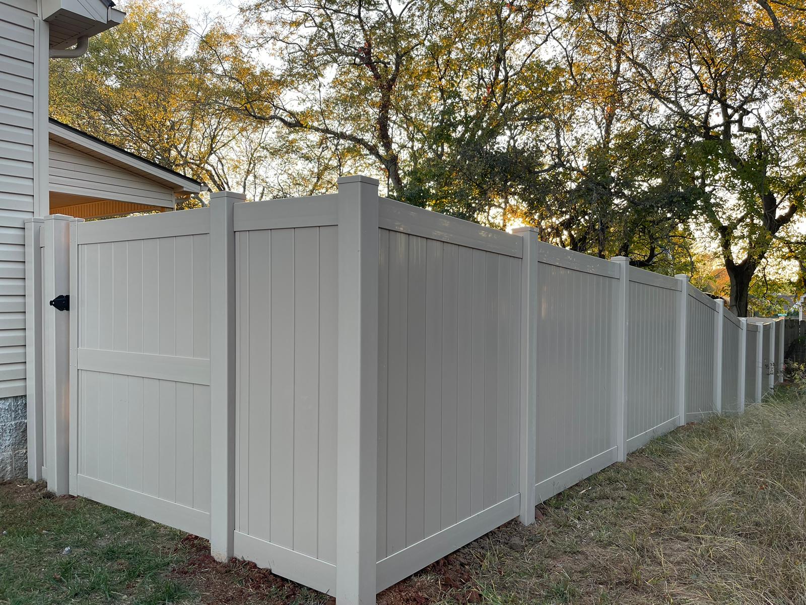 Tan vinyl privacy fence with gate